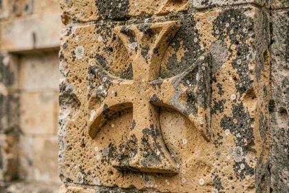 Croix des Templiers sculptée en relief sur une pierre calcaire ancienne, détail de la croix pattée médiévale
