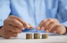 a person stacking coins on top of a table